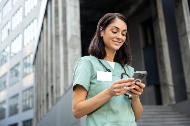 istock Young female doctor in a lab coat with a phone in hands 2189072639