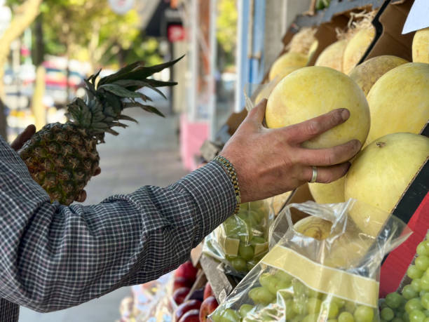 greengrocer with fruits displayed outside on the street