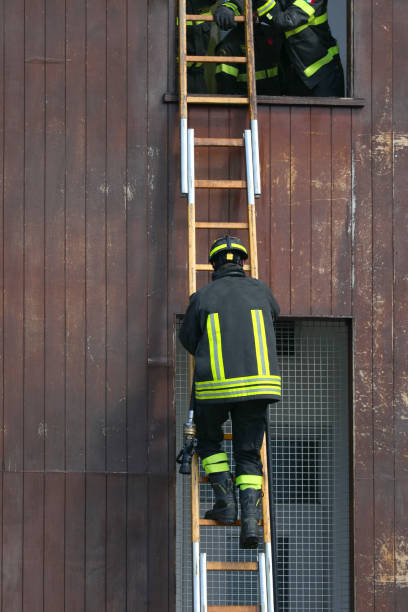 istock firefighter is climbing a ladder during a training exercise at a fire station to enter a building through a window and simulate a rescue 2189077901