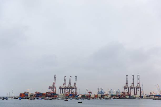 istock Industrial port with cranes and containers under cloudy sky. 2189077959