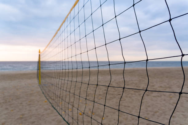 istock A volleyball net stretched on a deserted beach where soft sand meets the sea. 2189078020