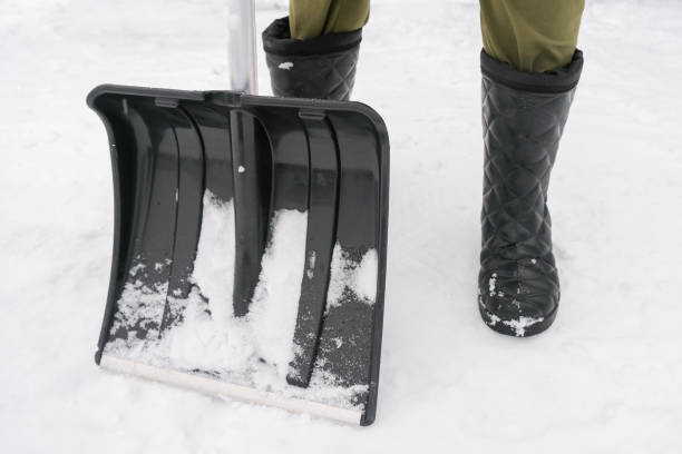 istock An unrecognizable person in snow boots holding a plastic shovel in order to clean, remove snow from a sidewalk for safety 2189078312