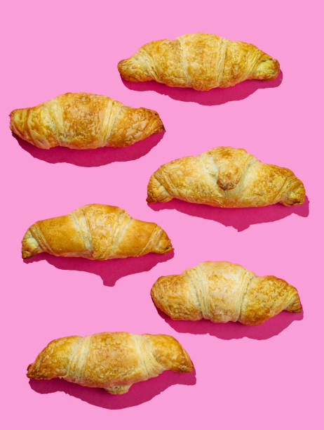 istock Flat lay of  fresh croissants on pink background with shadow. Creative layout and concept 2189079354