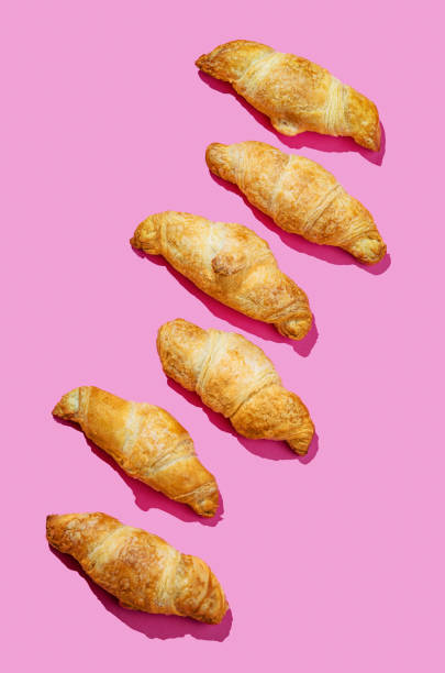 istock Flat lay of  fresh croissants on pink background with shadow. Creative layout 2189079639