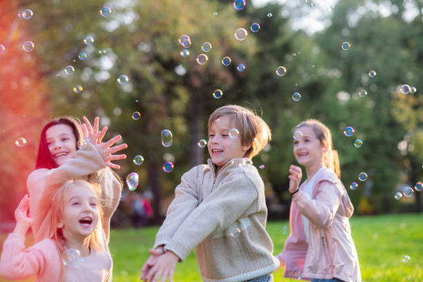 istock happy children play with soap bubbles, chase them, play 2189086930