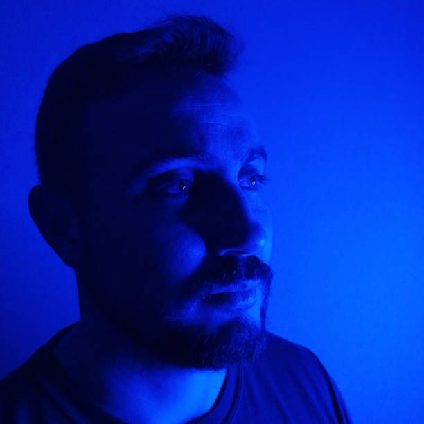 istock portrait of a handsome man in blue light 2189086954