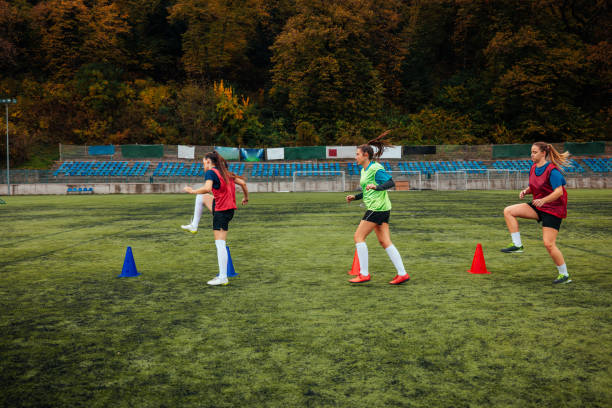 A young Caucasian women's soccer team are in the field outside having a practice.