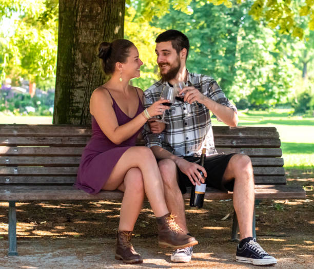 istock Happy couple enjoying in wine on bench in park 2189087311