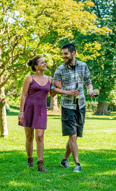istock Happy couple walking in park, drinking wine 2189087555