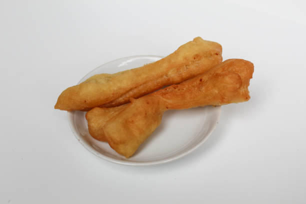 istock Cakwe or cakue, fried savory cake from Indonesia, on small white plate, isolated on white background 2189088087
