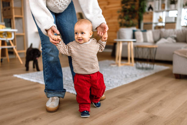 istock Mother helping to her son learn to walk at home 2189093703