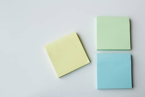 istock Three square pastel color sticky notepads over white background with copy space. 2189094127