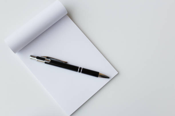 istock Black pen and white paper notepad banner background with copy space. 2189094128