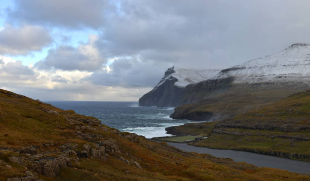 Aerial view of a soccer field surrounded by lake and ocean just outside the small village of Eidi on the north-west tip of Eysturoy on Faroe Islands.