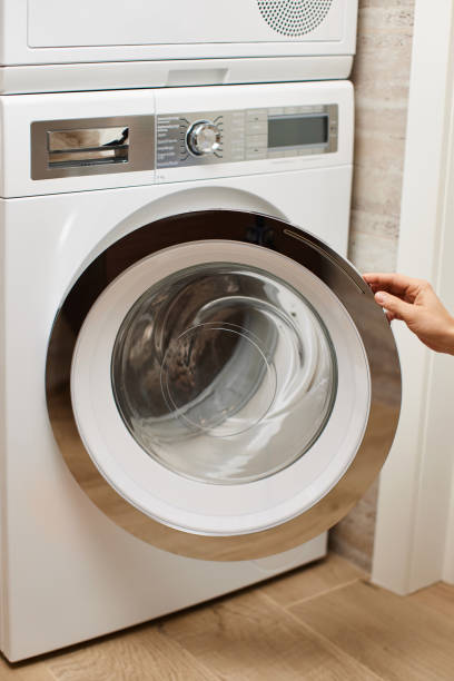 istock female hand opens the door in washing machine 2189097910