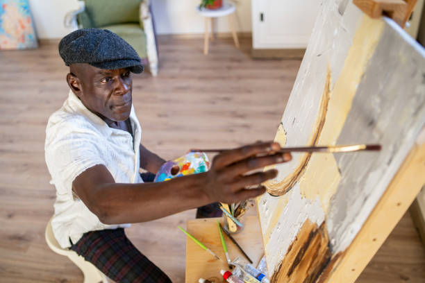 istock Senior artist painting on canvas at his home studio 2189100301