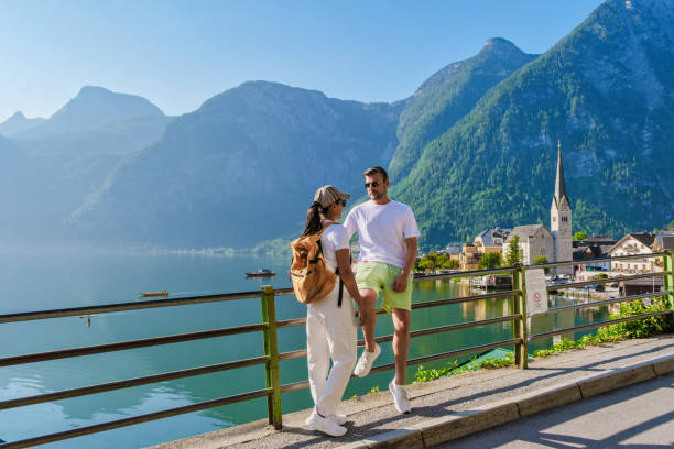 istock Couple savoring a sunny day by Hallstatt's serene lakeside, surrounded by stunning mountains 2189111564