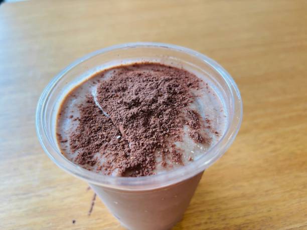istock Chocolate protein smoothie topped with chocolate powder on wooden surface 2189114799