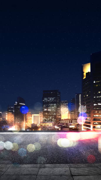 Empty rooftop with view of modern building skyscrapers and futuristic architecture with colorful bokeh light on night scene background. Mock up or template. copy space. Cityscapes background