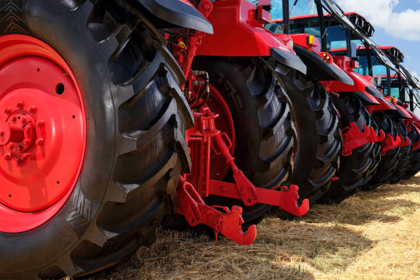 istock Several large modern red tractors standing in a field. 2189125472