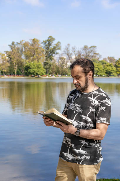 istock Man in his 50s reading by a lake 2189125686