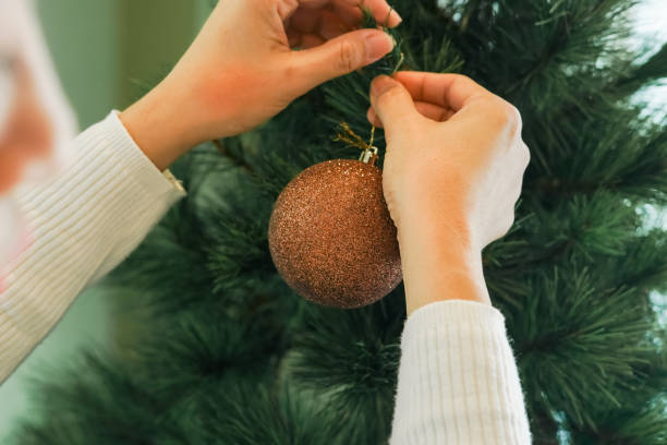 istock Close-up woman hand decorating a Christmas tree 2189126115
