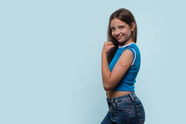 istock Girl flexing arm and showing bandage after vaccination 2189127681