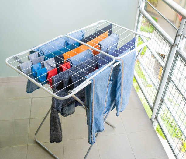 istock Laundry drying on a balcony clothes rack, with various garments including jeans and shirts 2189132892