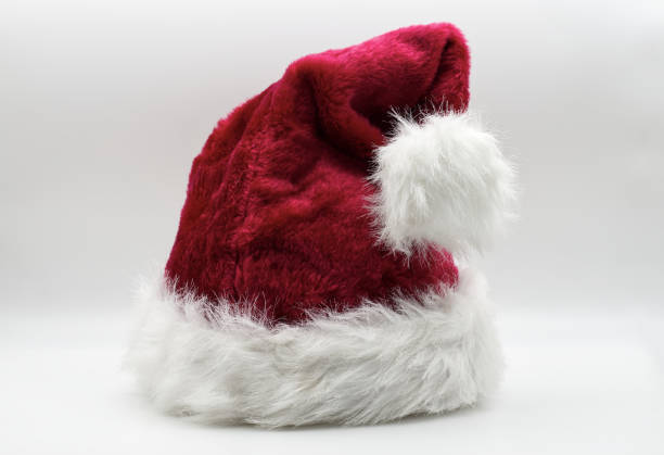 Front view of a classic red Santa Claus hat with soft white fur trim and fluffy pom-pom, isolated on a clean white background. The iconic Christmas accessory evokes festive joy, warmth, and traditional holiday spirit. Perfect for winter advertising, Christmas design layouts, holiday greeting cards, or seasonal retail visuals.