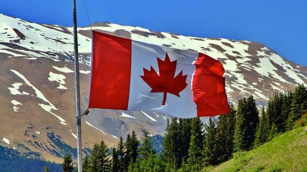 istock Canadian Flag Waving Against Rocky Mountain Backdrop 2189136001