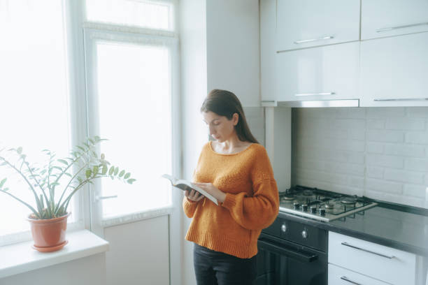 istock Focused brunette woman reading at home, immersed in spiritual study 2189140129