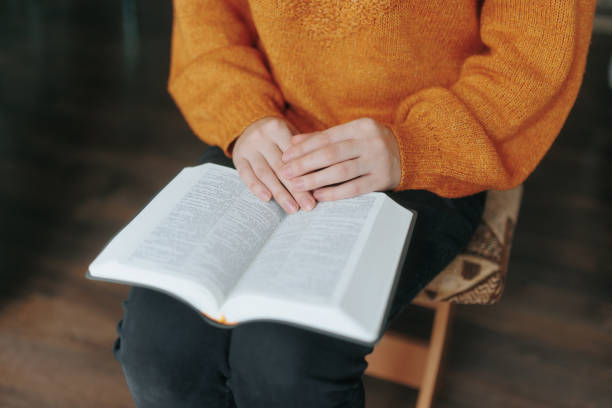 istock Person is sitting on a stool and reading a book 2189140145