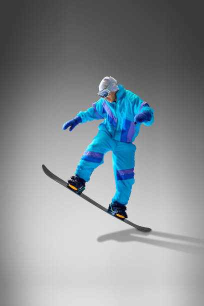 istock Snowboarder showcasing dynamic moves in bold gear, against grey studio background. Perfect for winter sports and tourism concepts. 2189147638