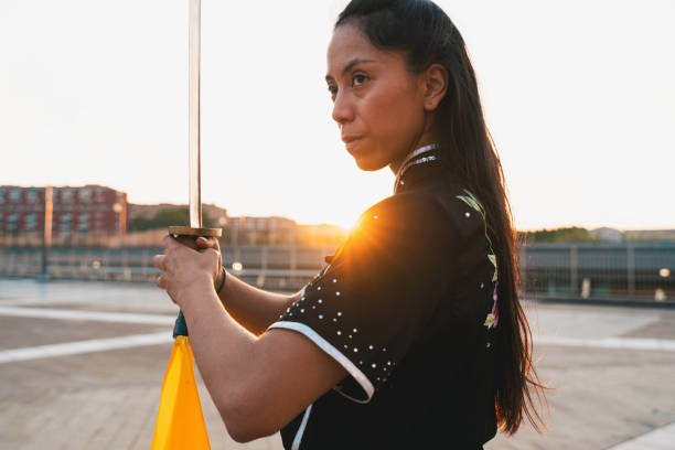 Chinese young woman practicing wushu kung fu with weapons outdoor. Young girl training martial arts form for the competition.
