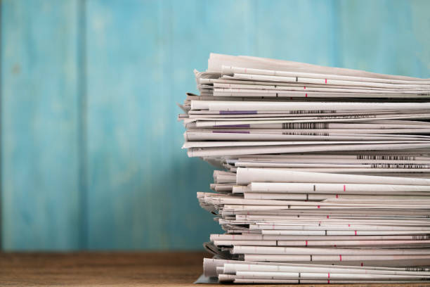 close up newspapers folded and stacked background on the table with green background.