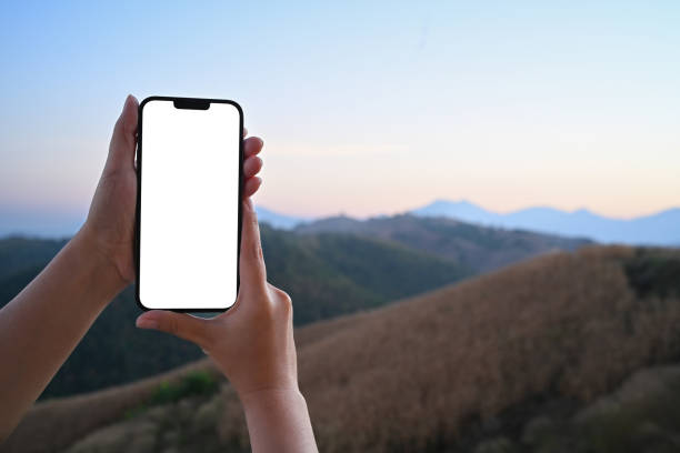 istock Hand holding smartphone against a beautiful mountain landscape and serene evening sky 2189150030