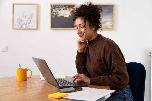 istock Young woman working from home on laptop smiling 2189150343