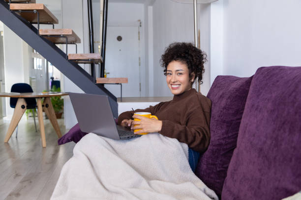 istock Young woman working remotely from home using laptop and drinking coffee 2189150379
