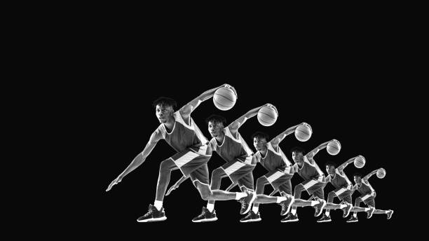 istock Basketball player sprinting forward with ball, sleek black and white design. Stroboscopic effect accentuates phases of motion, showcasing intensity. 2189150955