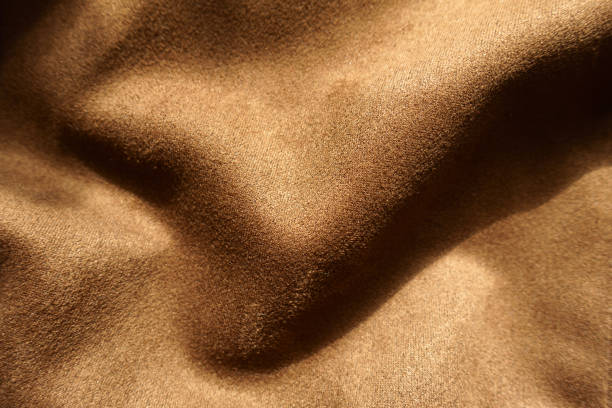Soft folds on chocolate brown faux suede polyester fabric