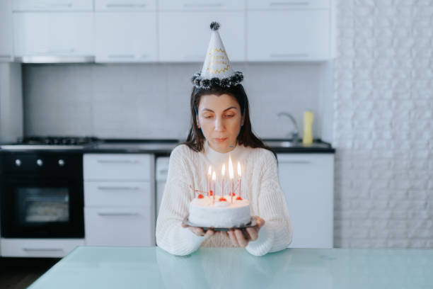 istock Sad woman sits alone with lit cake, celebrating her birthday in the kitchen. 2189154331