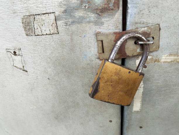 istock A rusty steel padlock securing an iron door. 2189154924