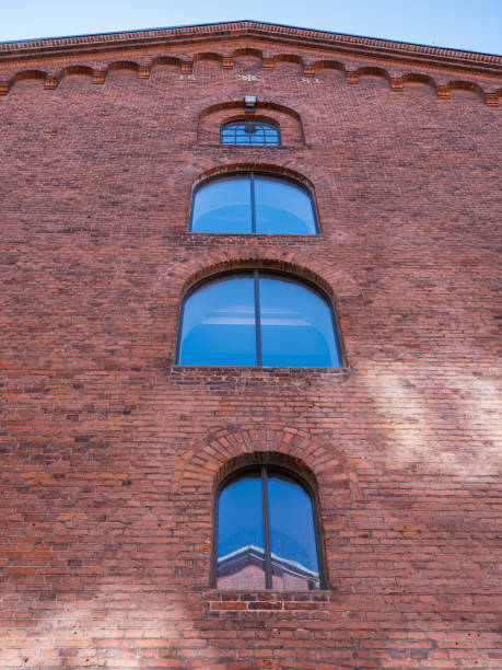 istock Arched windows with blue glass adorn a reddish-brown brick building 2189155885