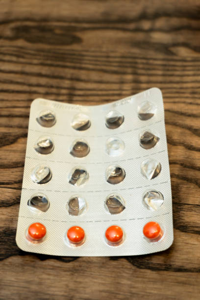 istock Blister pack with orange and clear capsules on wooden surface 2189158544