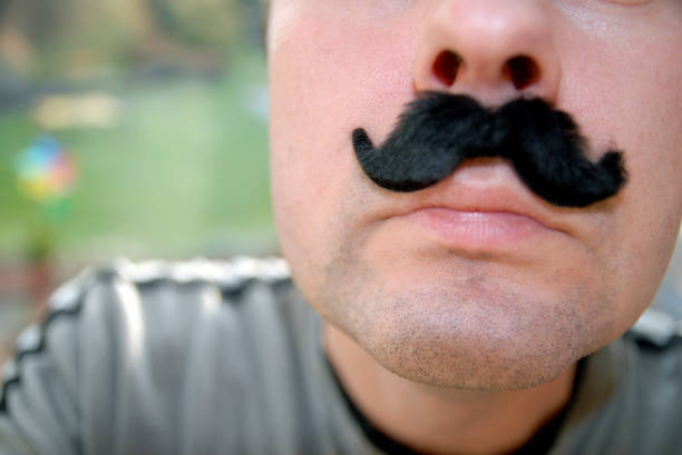 istock Close-up of a man age 20-30 wearing a false mustache. 2189158593
