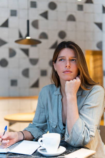 istock Dreamy woman with notebook and tea in cafe 2189159614