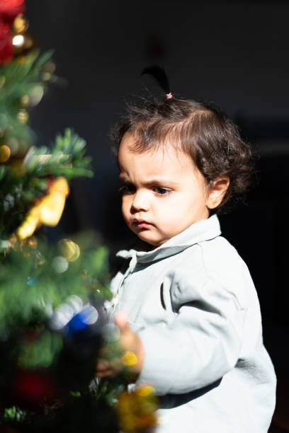 istock Baby girl exploring christmas tree decorations at home 2189159624
