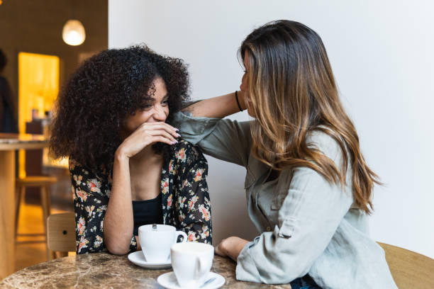 istock Smiling diverse girlfriends interacting at table in coffee house 2189159626