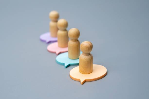 istock Four wooden figures, each standing on a differently colored speech bubble. 2189159960