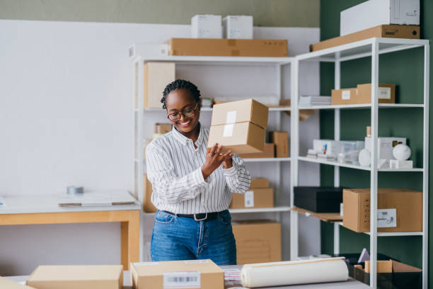 istock Woman Packing Box in Modern Workspace With Shelves and Boxes 2189160041